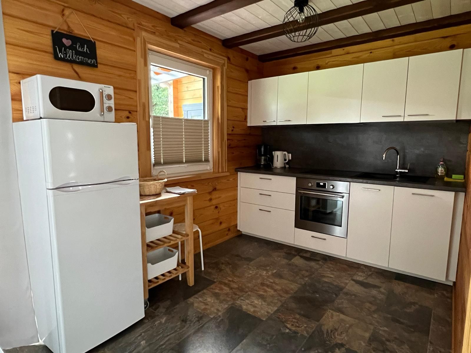 Küche mit Herd, Backofen, Kühlschrank und Mikrowelle