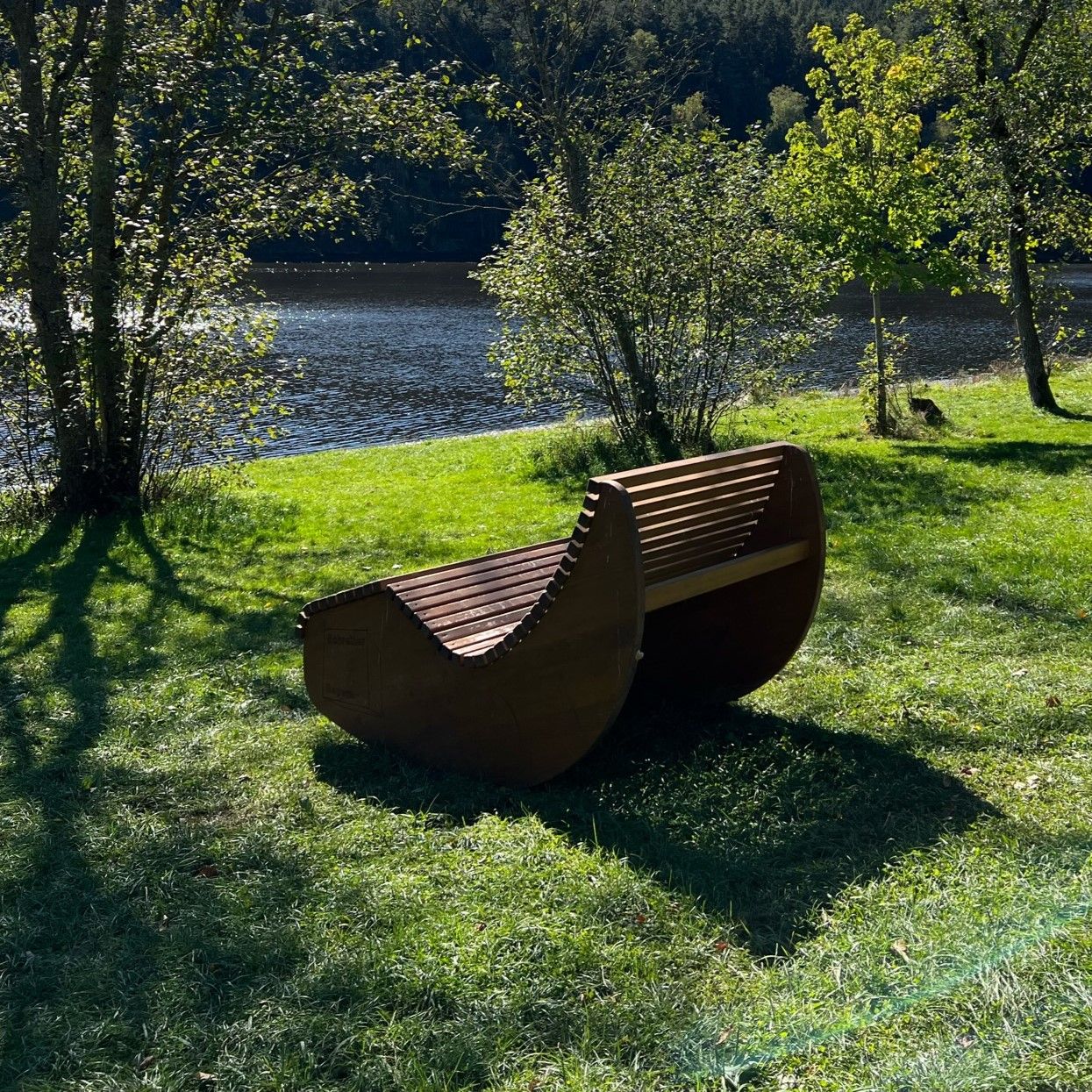 Holzliege im Garten mit Blick auf den See